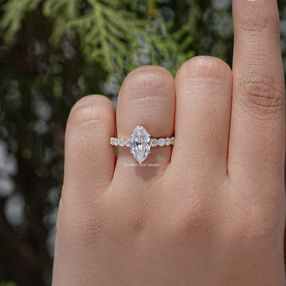Moissanite ring with oval-cut center stone and small accent stones on a slim band