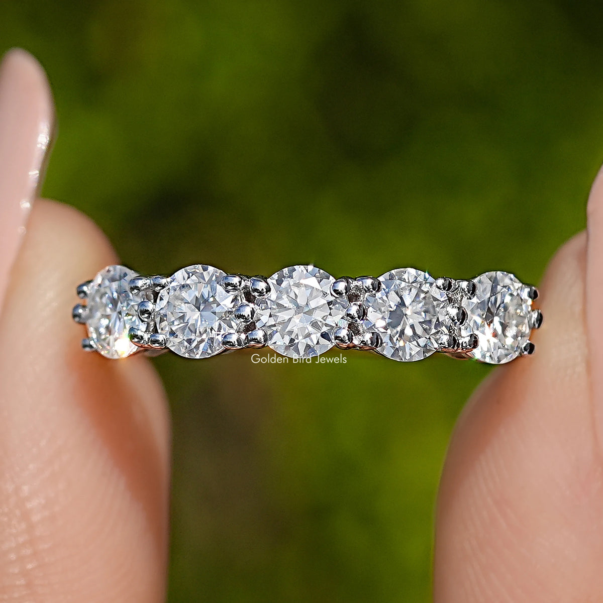 Five round moissanite stones across the band, prong-set 925 sterling silver close-up