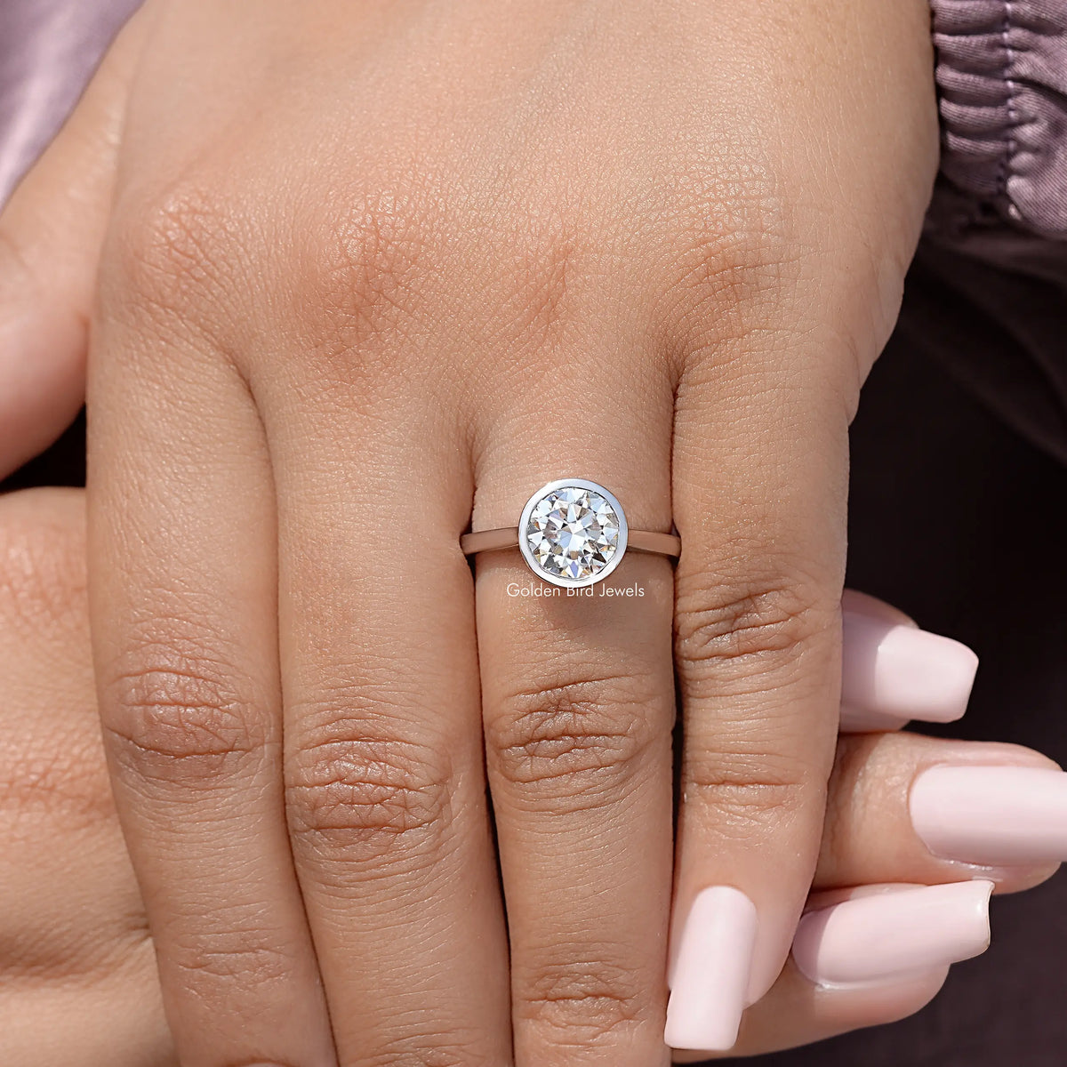 Sterling silver round moissanite bezel wedding ring, centered stone view on hand