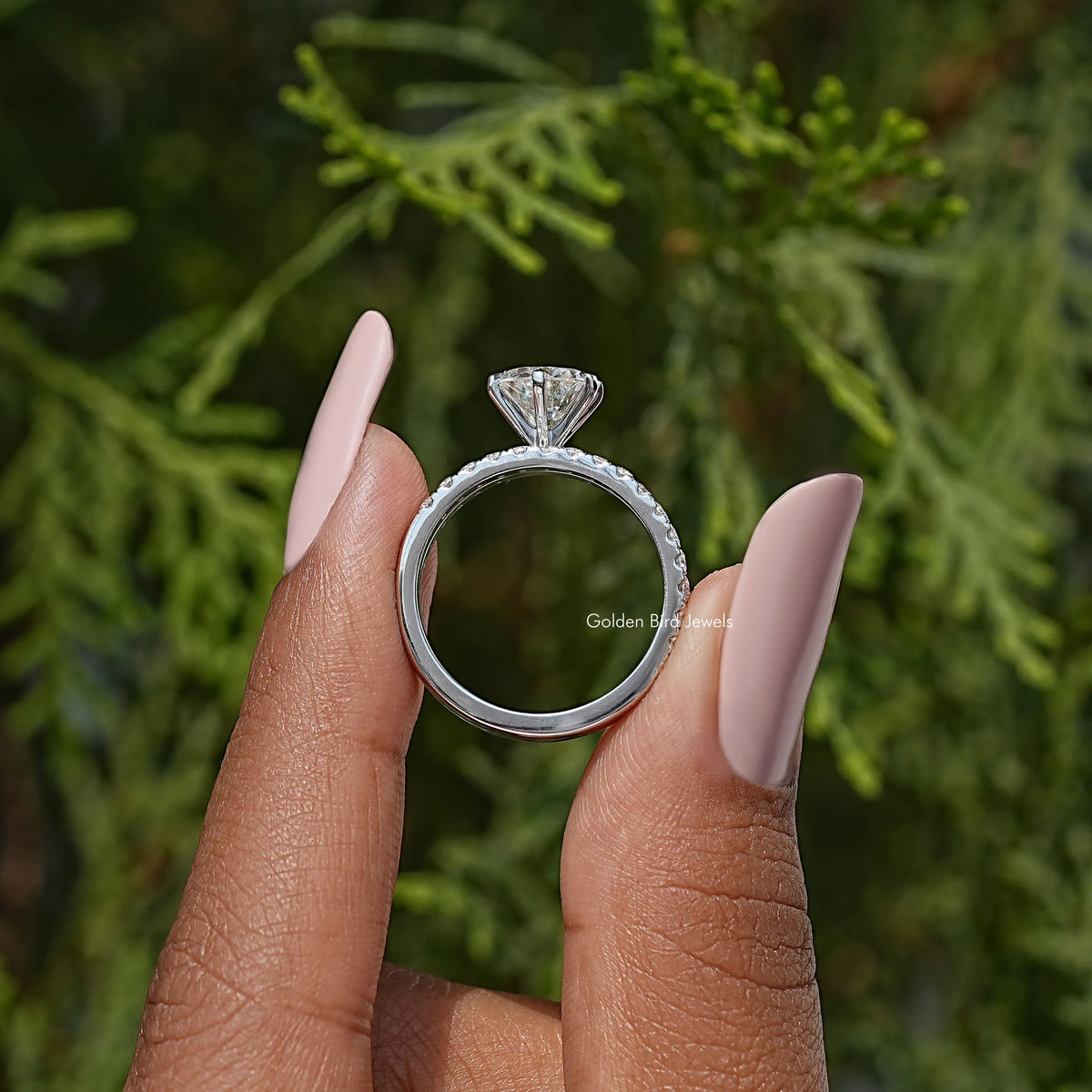 Round cut moissanite engagement ring in silver, side view with raised solitaire setting