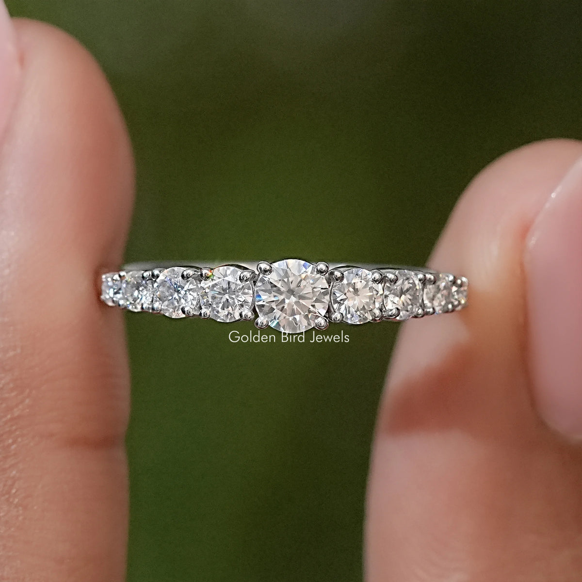 Silver-toned moissanite engagement ring with round stones in a prong-set band
