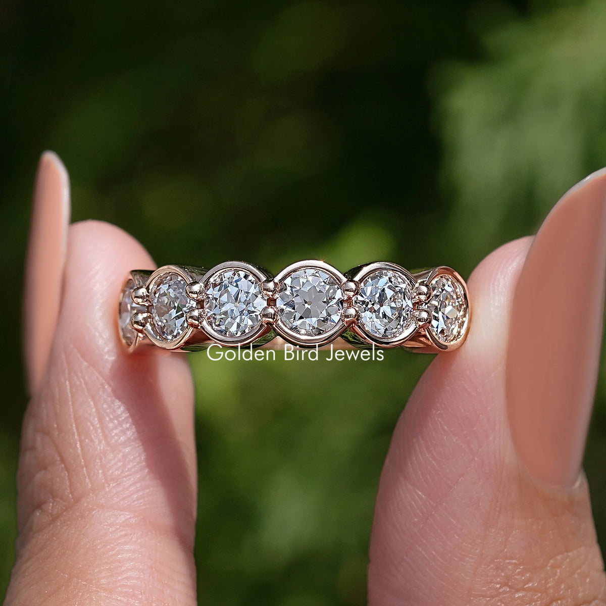 Rose-gold tone wedding band with bezel-set round diamonds in a scalloped row