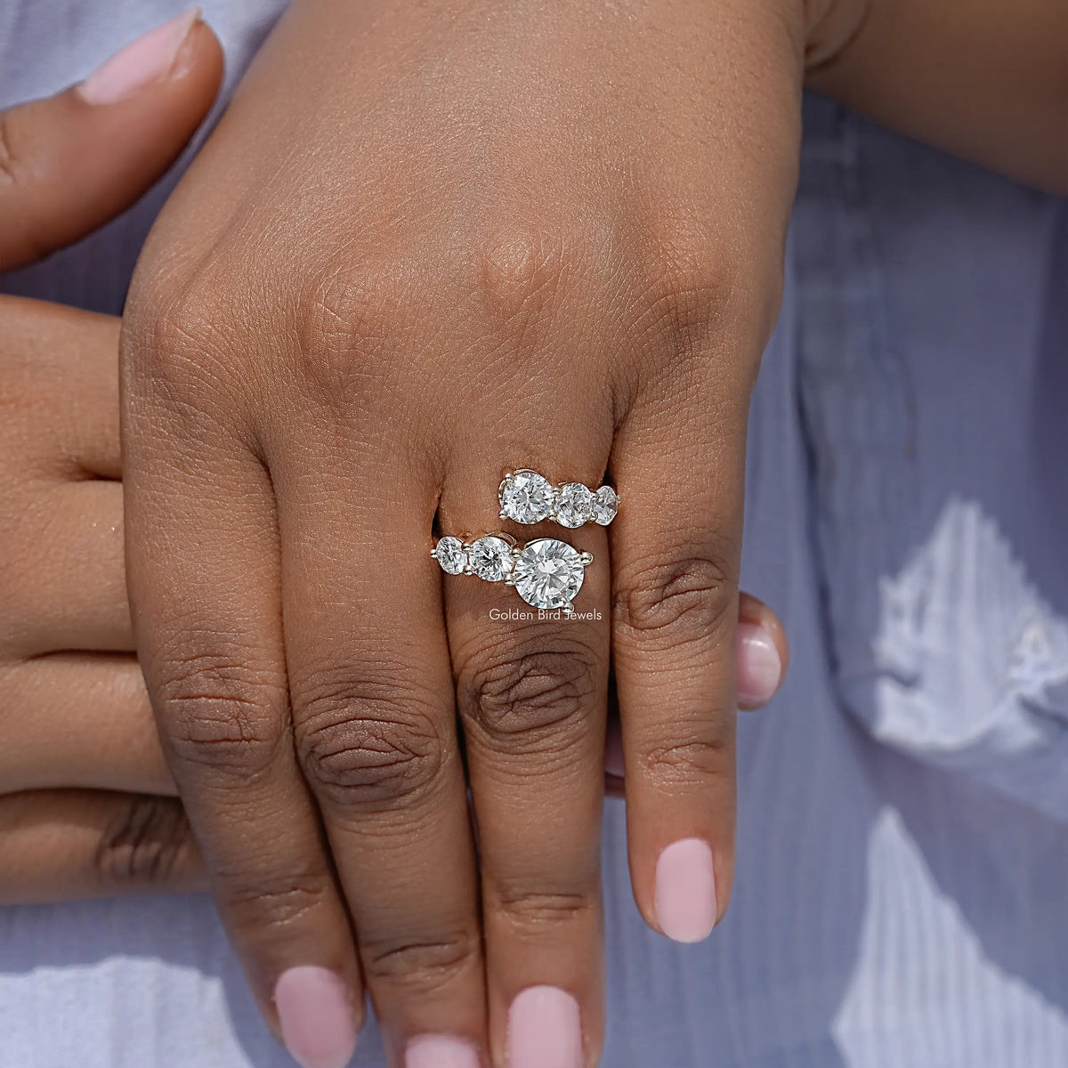 Cluster bypass ring with round stones, worn on hand on a slim band