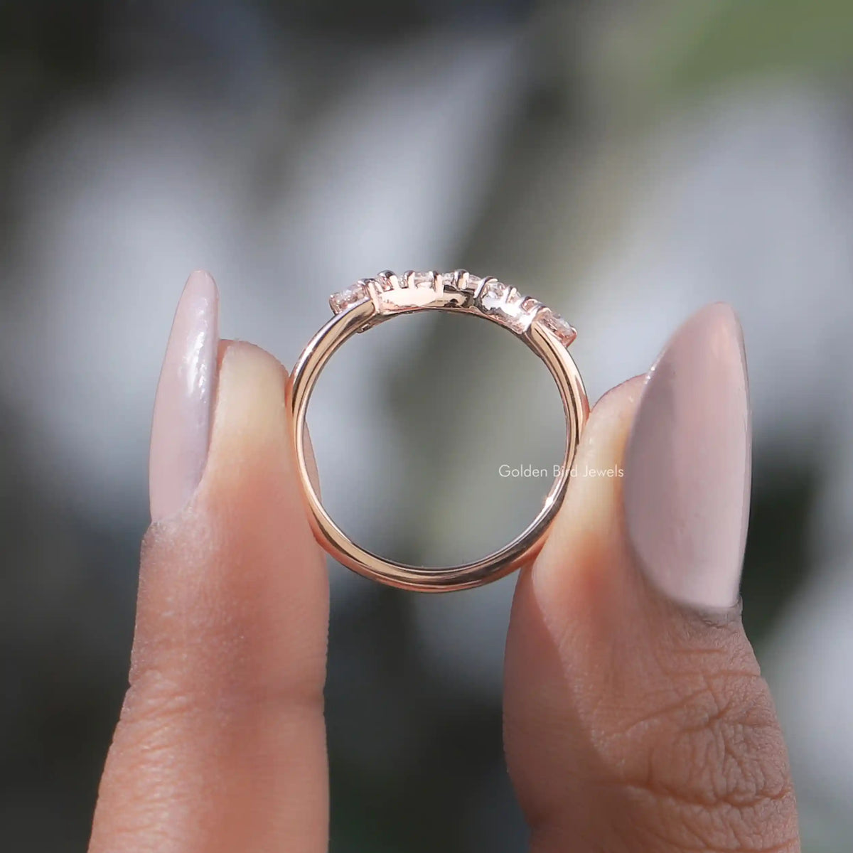 Rose-gold tone curved band with small round diamonds in an open setting