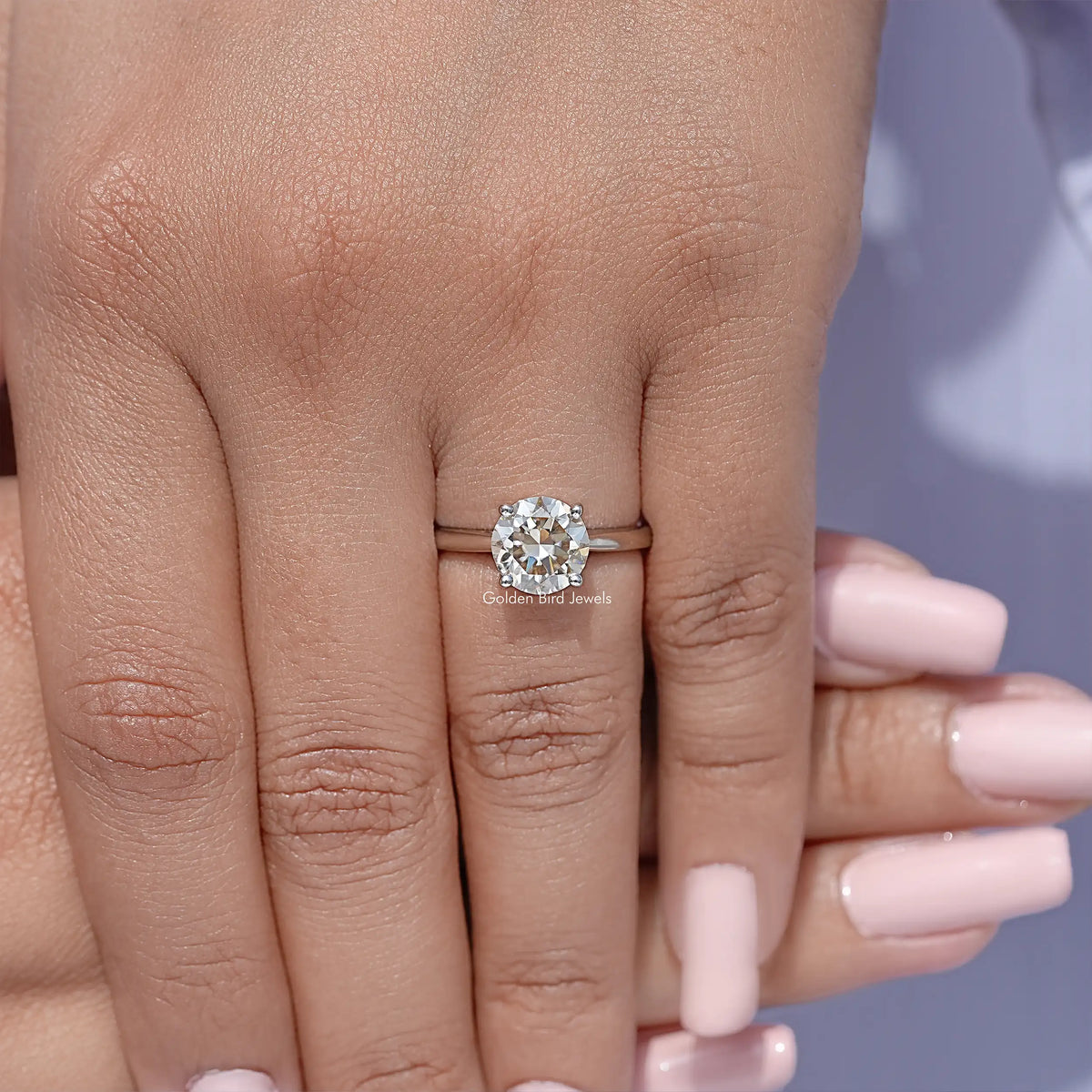Sterling silver round moissanite solitaire ring on finger, front view