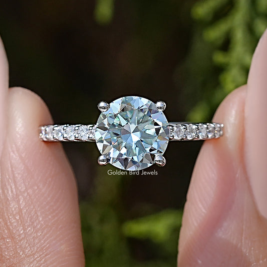 Close-up: round-cut moissanite center with side accent stones on sterling silver