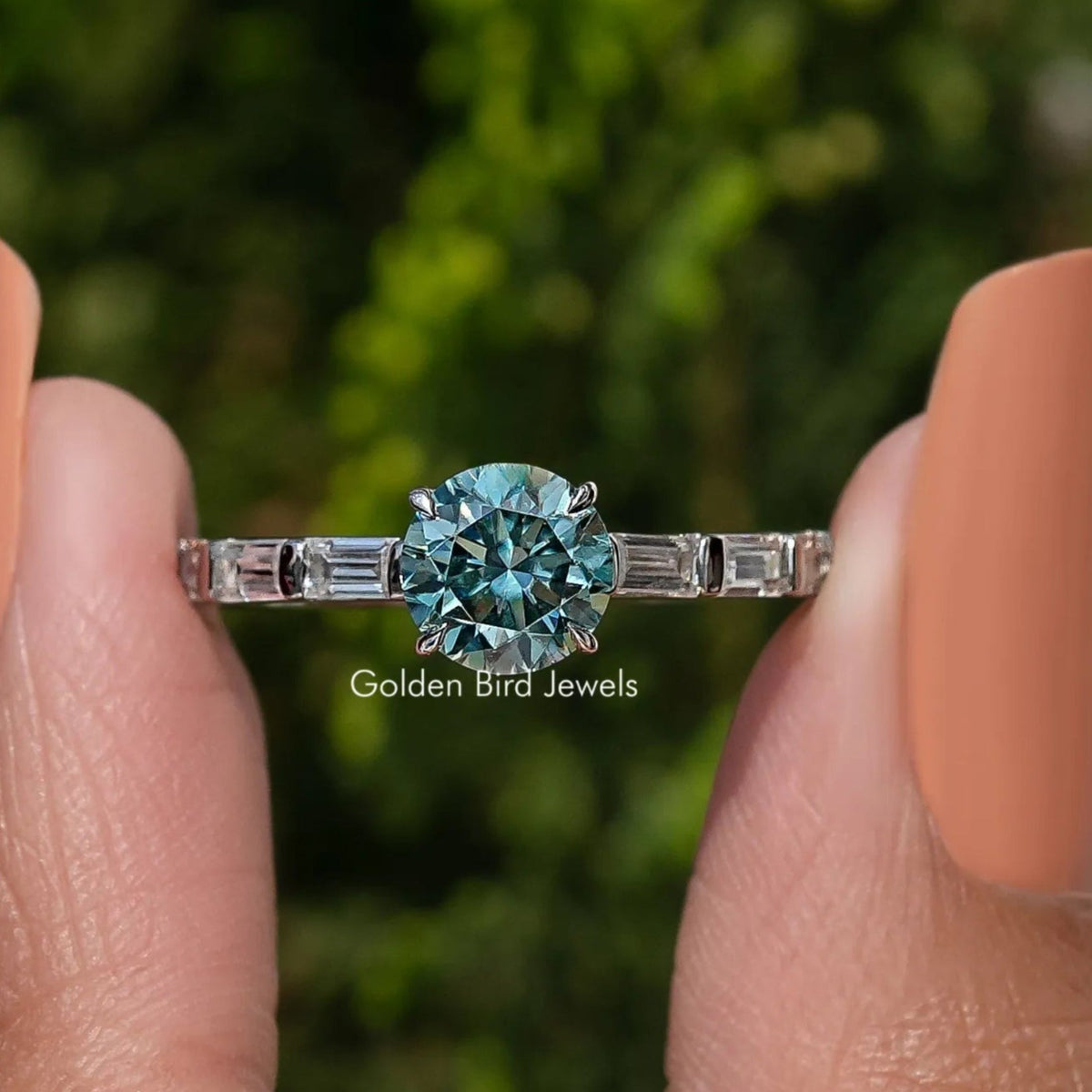 Sterling silver ring with round blue-green moissanite center and baguette side stones