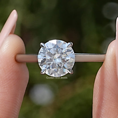 Round solitaire engagement ring with large clear center moissanite and thin metal band