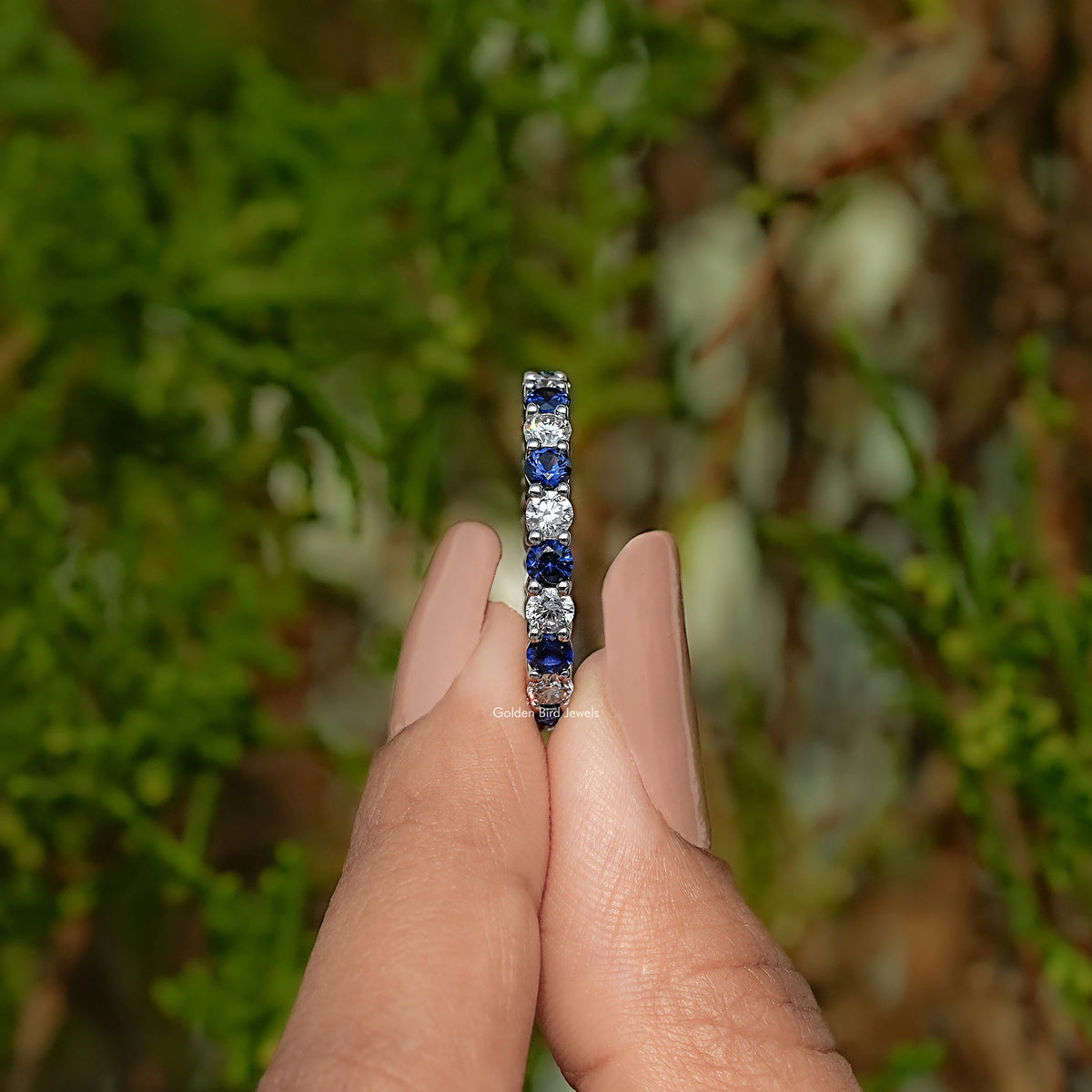 Eternity wedding band with tall center row of round blue gemstones