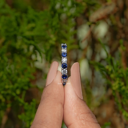 Eternity wedding band with tall center row of round blue gemstones
