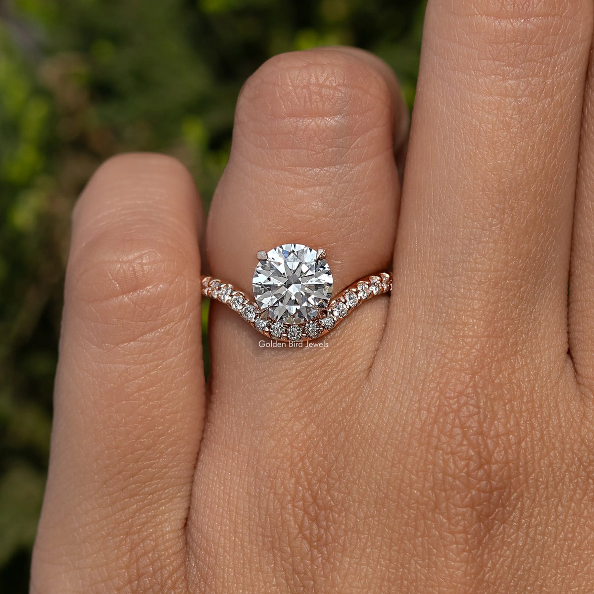 Lab grown round cut curved accent engagement ring with pavé band on a finger