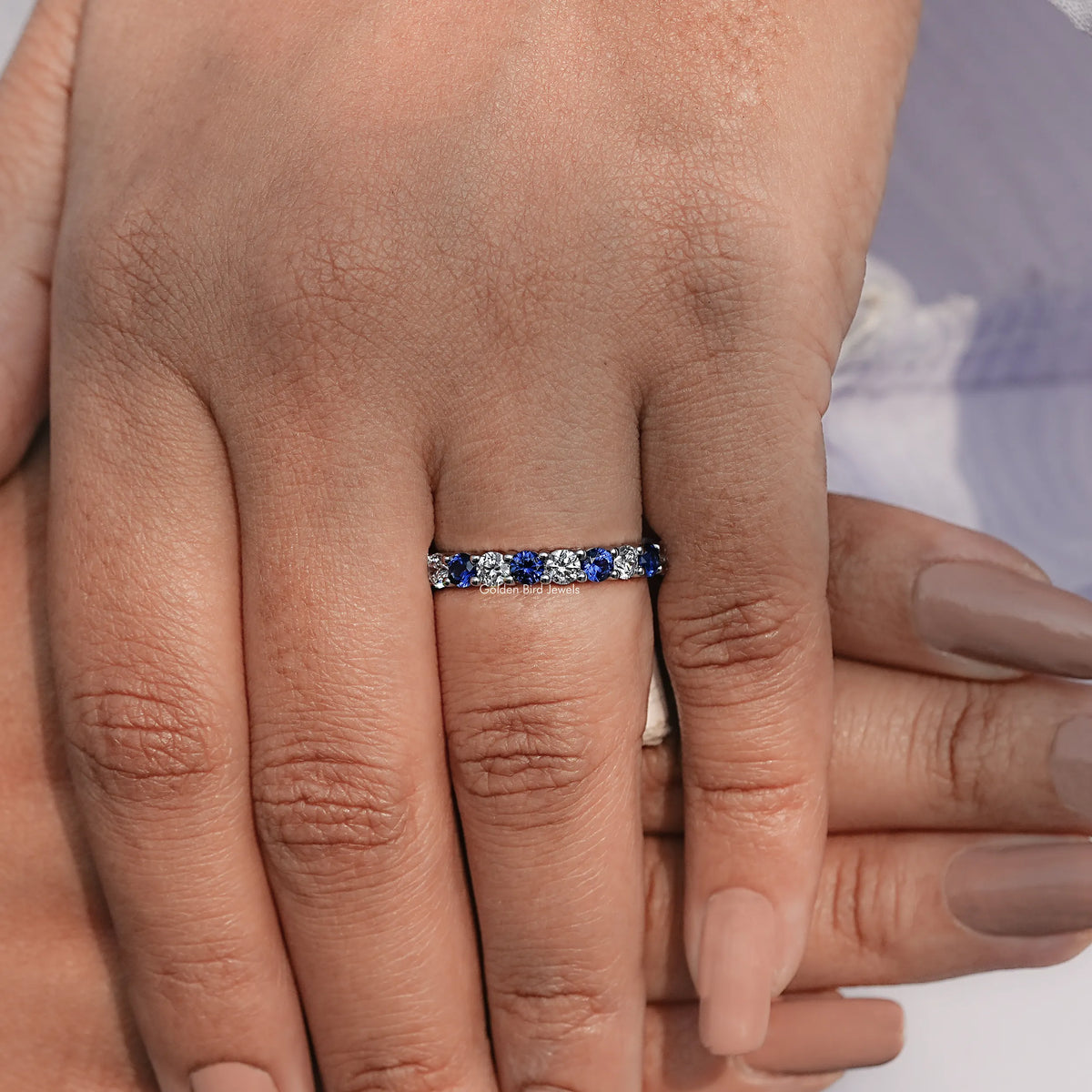 Blue gemstone eternity wedding band with sparkling stones along the top
