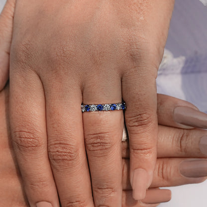 Blue gemstone eternity wedding band with sparkling stones along the top