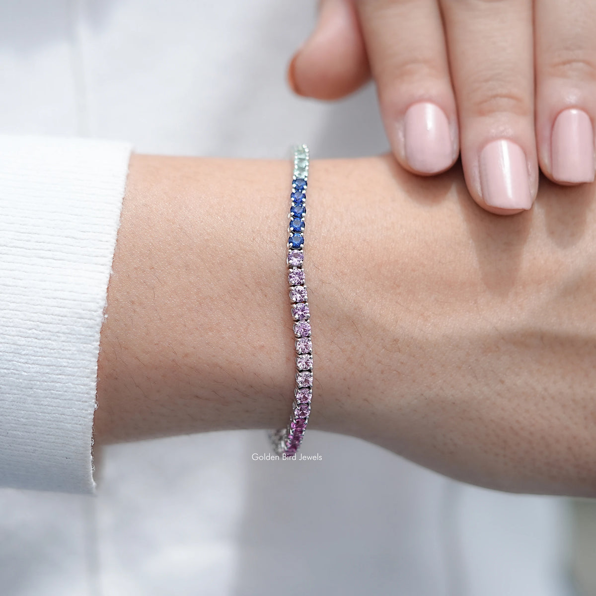Multi-color gemstone tennis bracelet on wrist, mixed purple and blue gemstone row
