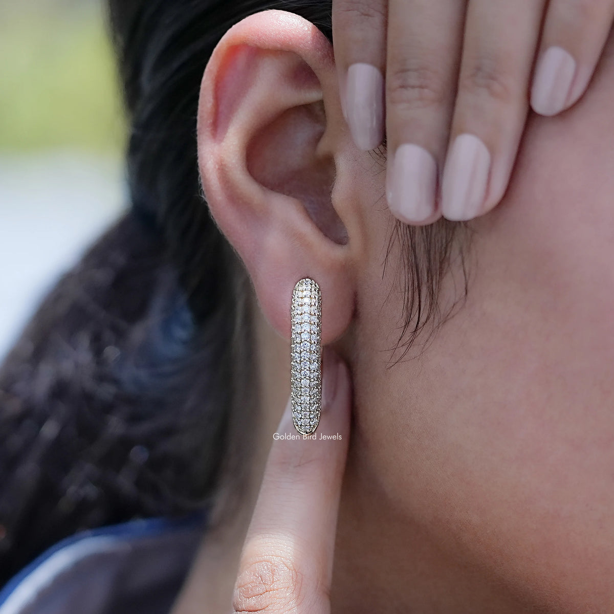 Round cut lab diamond pave-set hoop earring on an ear piercing