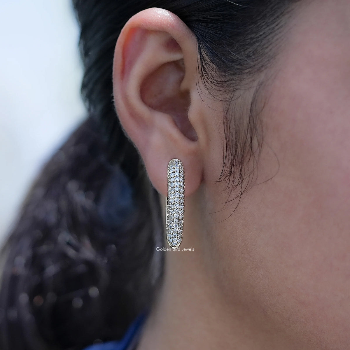 Pave set round cut lab diamond hoop earring worn on ear