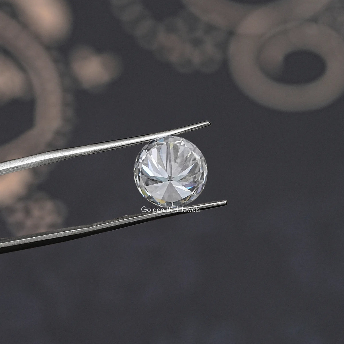 Loose round-cut lab diamond in silver tweezers, face-up round brilliant view