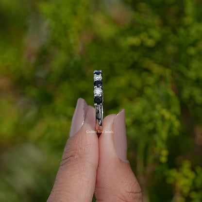 Silver eternity ring end view with stacked round dark and clear gemstones