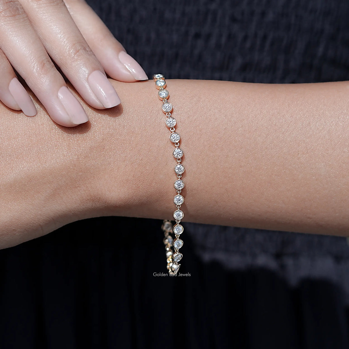 Gold-tone tennis bracelet with sparkling round clear stones along the wrist