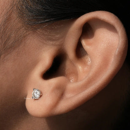 In ear front view of round cut moissanite solitaire stud earrings
