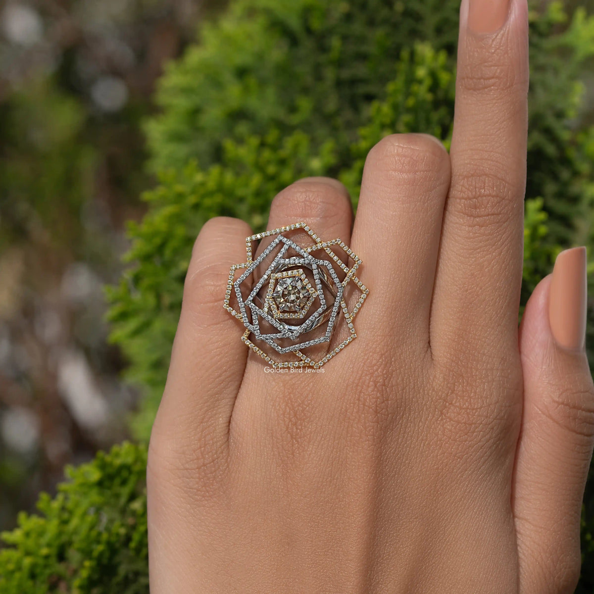 Sterling silver moissanite cluster engagement ring with round floral design on finger