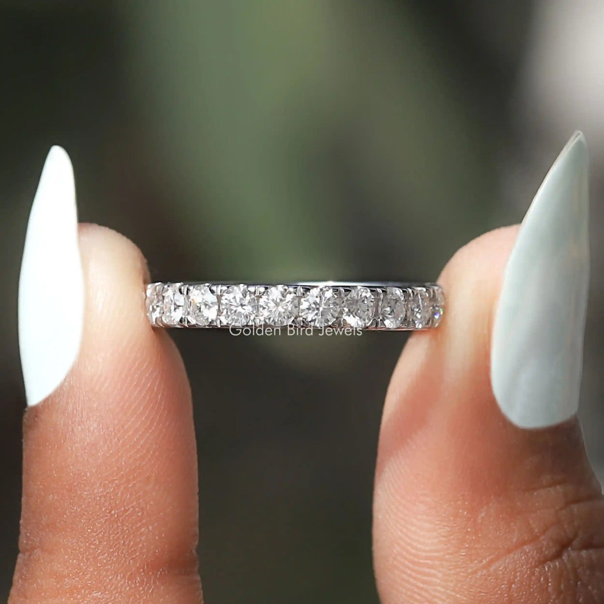 Sterling silver eternity band with prong-set round-cut stones across the top