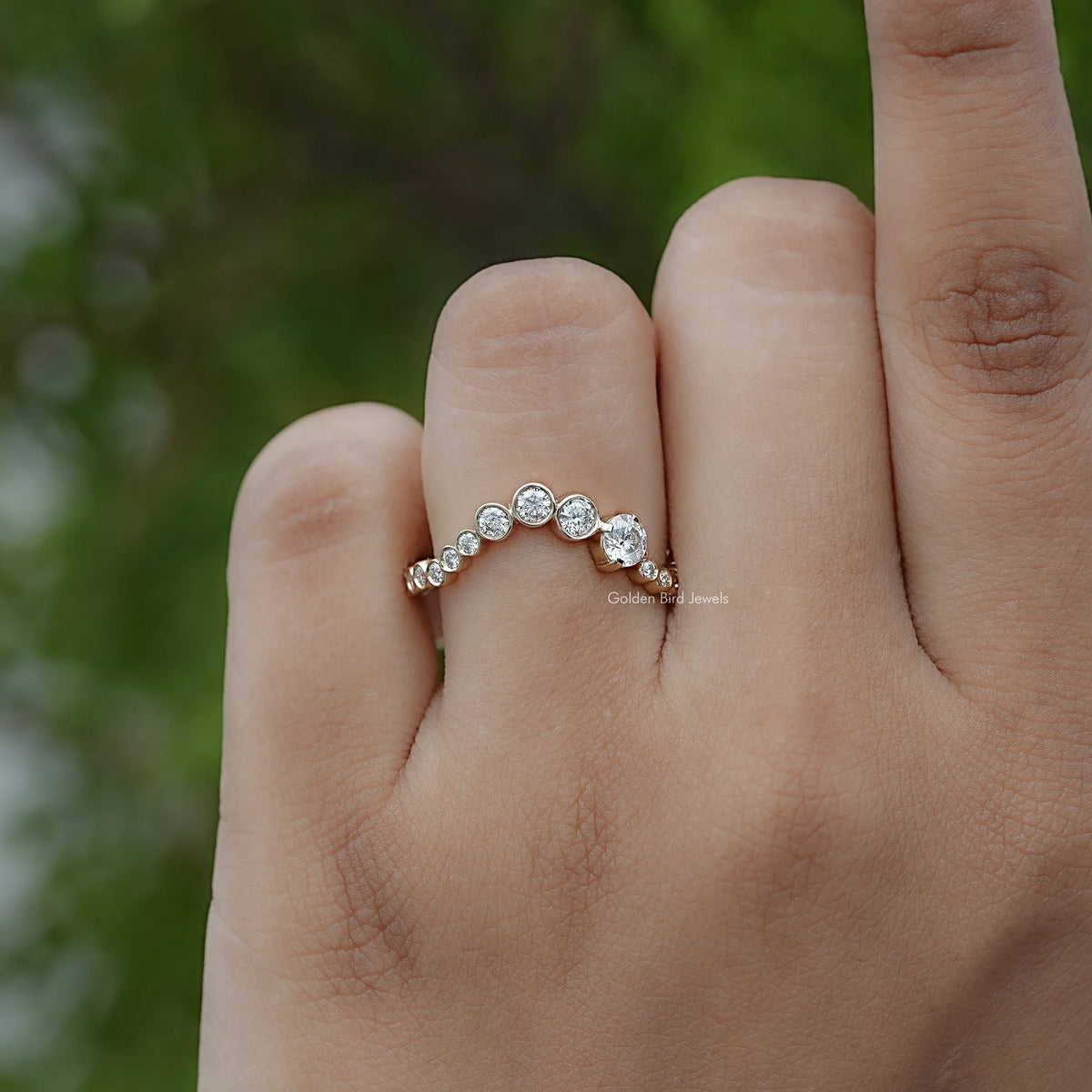 Silver curved full eternity band with round stones, close-up on finger