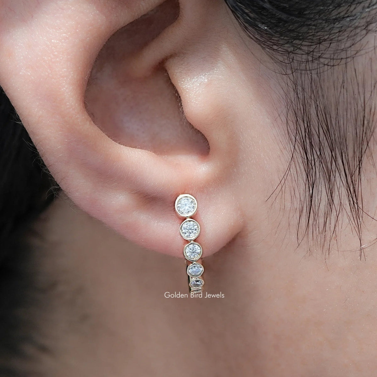 In Ear View Of Round Cut Moissanite Graduated C Hoop Earrings