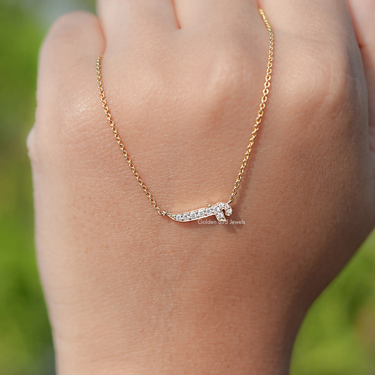 Gold-tone chain necklace with a small round-cut stone initial pendant.