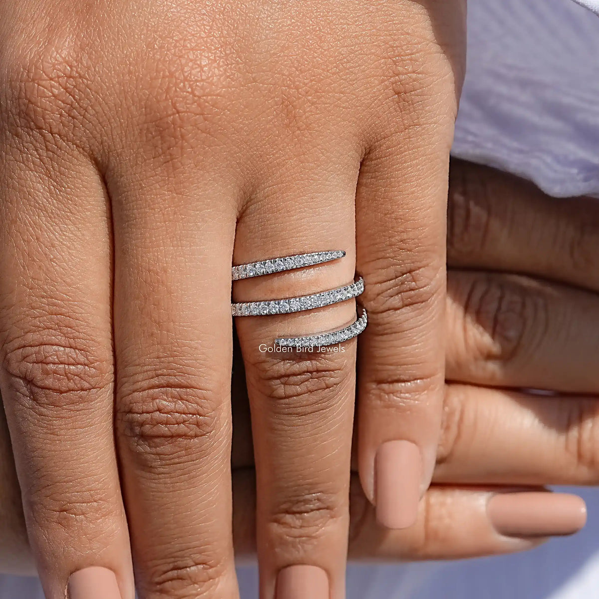 Silver moissanite spiral eternity band with round-cut stones, worn on hand