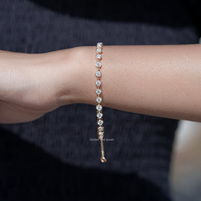 Gold-tone bracelet featuring a row of round clear gemstones on a fine chain
