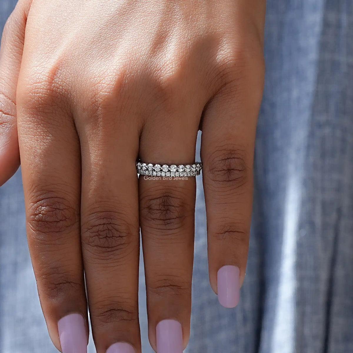 Silver two-row eternity band ring with round stones on several fingers