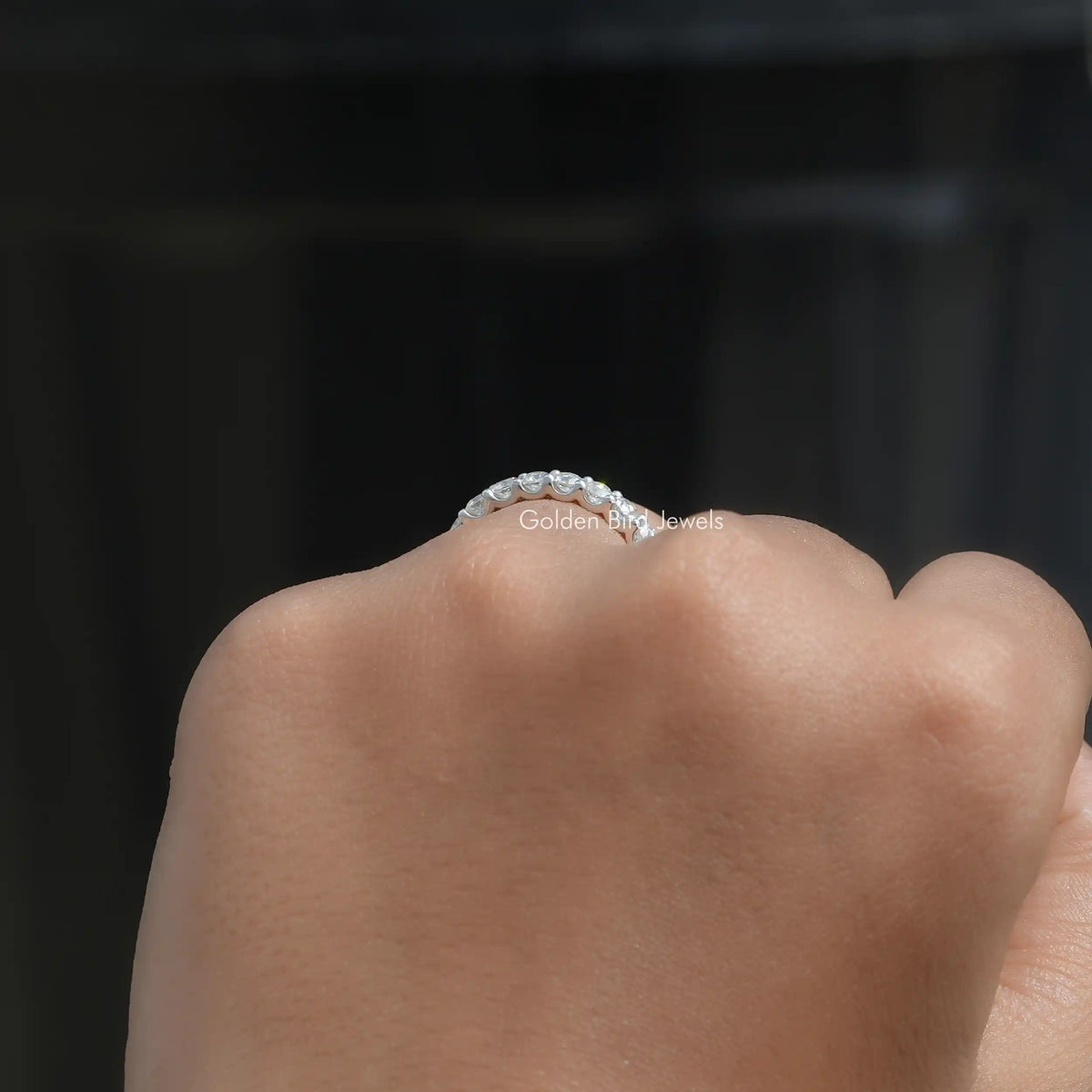 3/4 eternity band ring with small round-cut moissanite stones, viewed from above