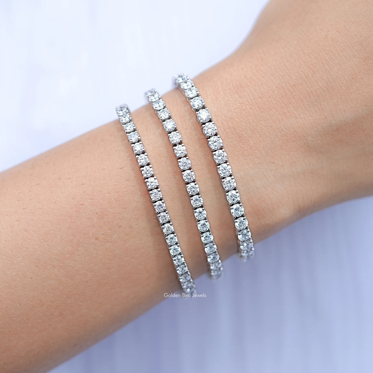 Silver round-cut lab diamond tennis bracelet, slender diamond bands on wrist
