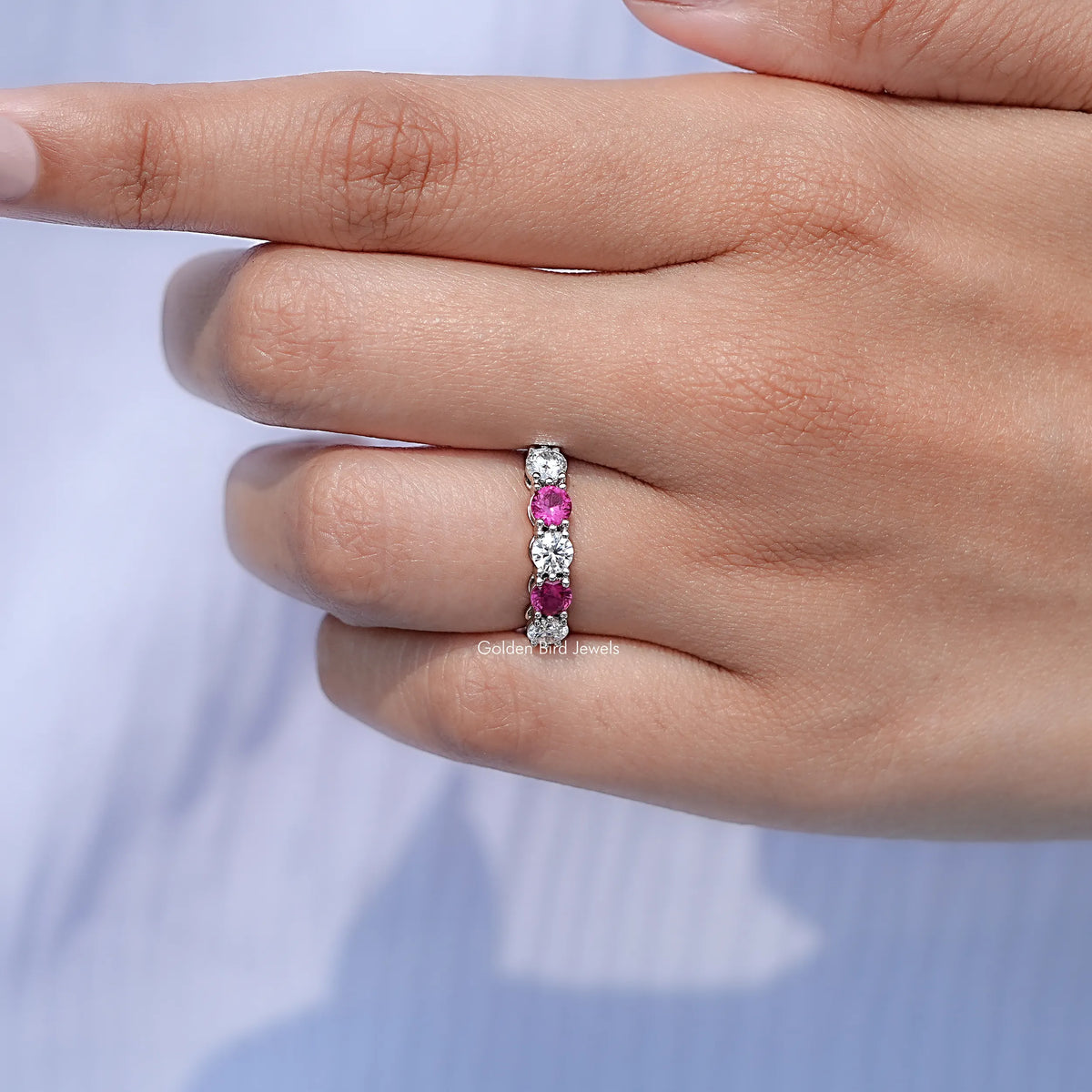 In finger front view of Round Gemstone Wedding Band in unique shape
