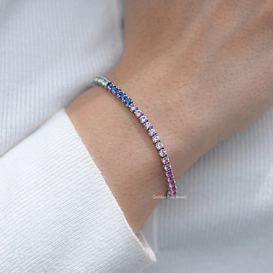 Multi-color gemstone tennis bracelet on wrist, side view with blue and lavender stones