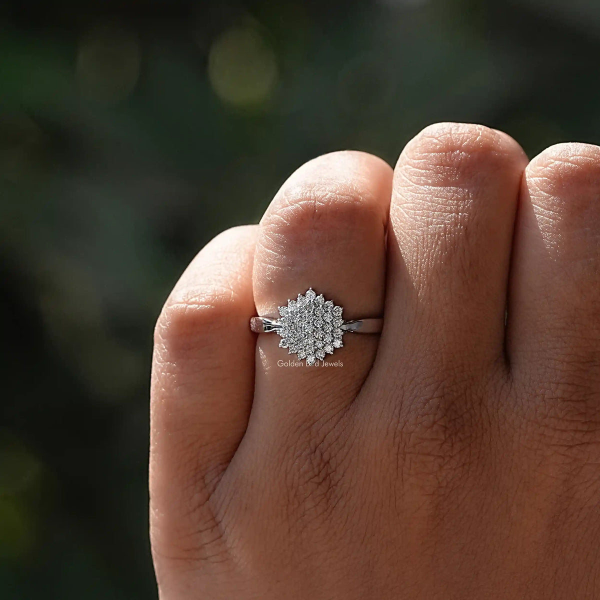 White gold ring with round lab-grown diamonds on slightly folded hand.