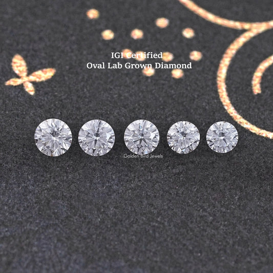 Loose round-cut lab-grown diamonds, five round stones on dark fabric