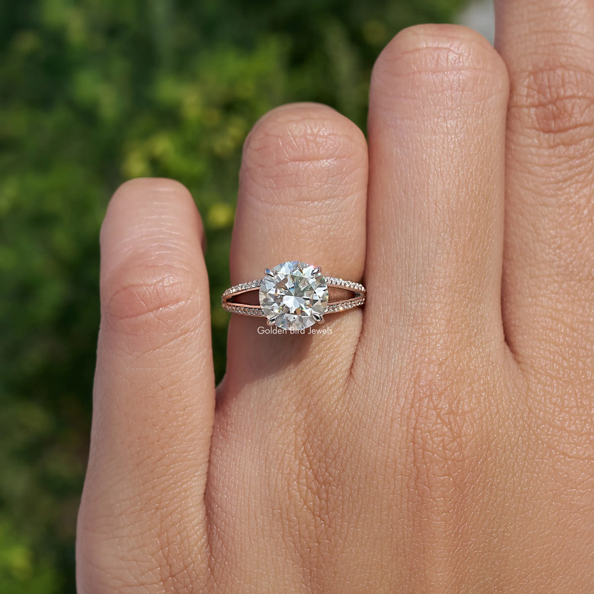 Round cut moissanite engagement ring with accent band on a hand