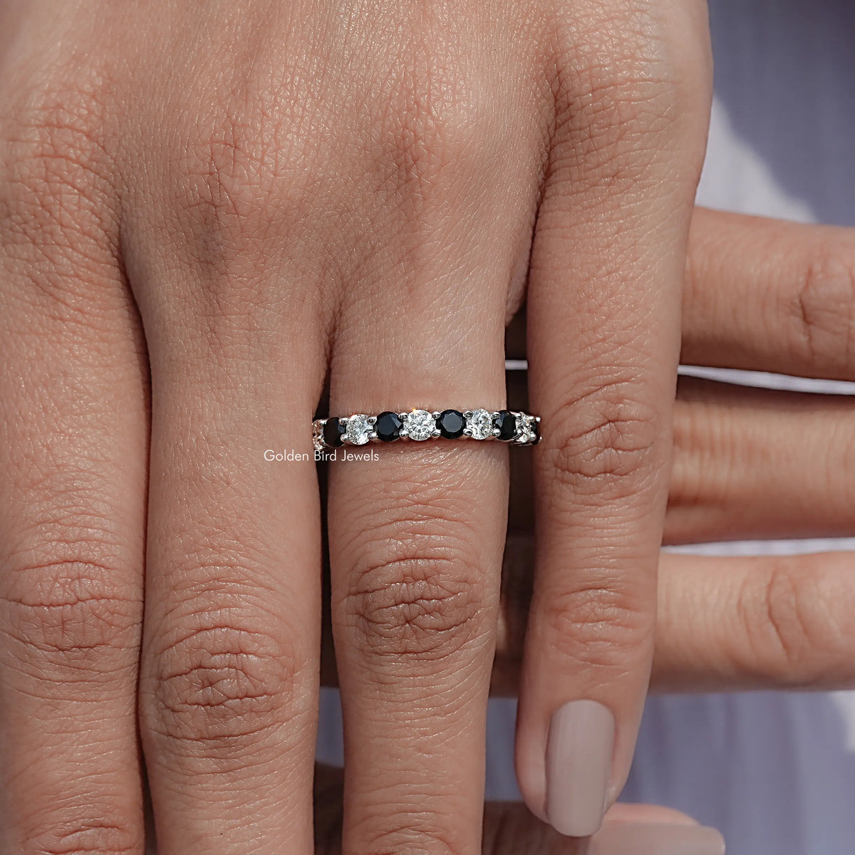 Silver eternity band with alternating round clear and dark gemstones