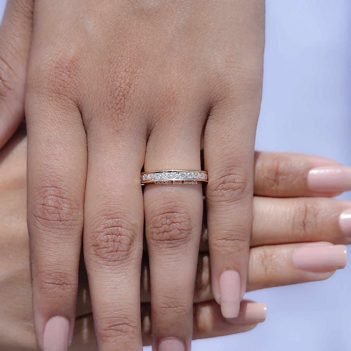 Silver half-eternity ring with channel-set round stones, close-up on hand