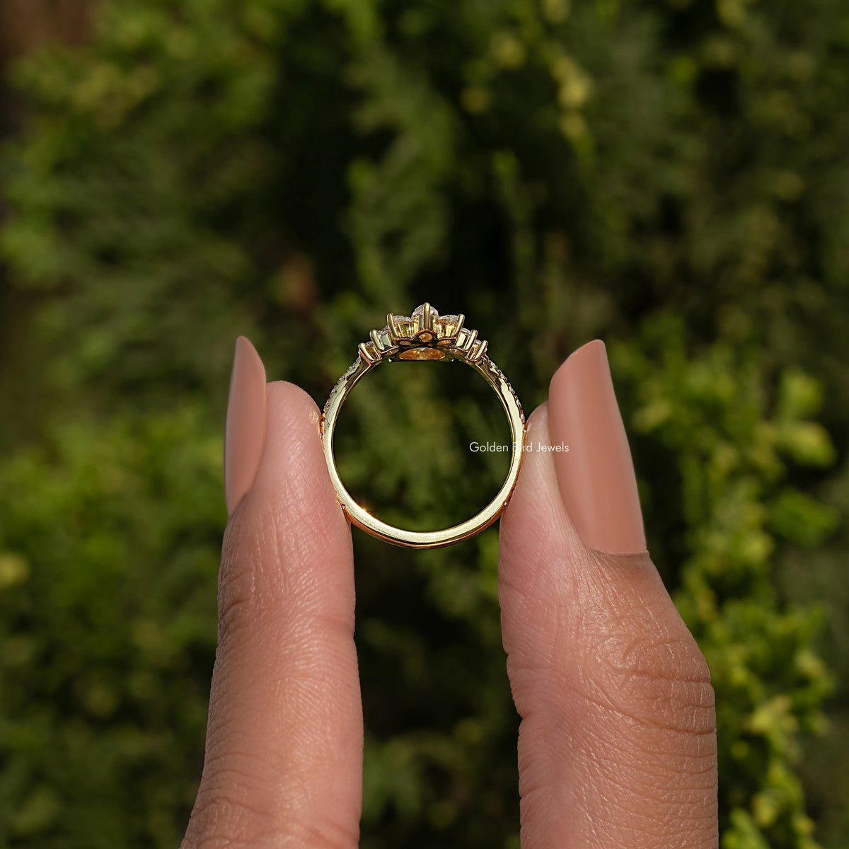 Gold-tone curved engagement ring band with round center stone, side halo detail