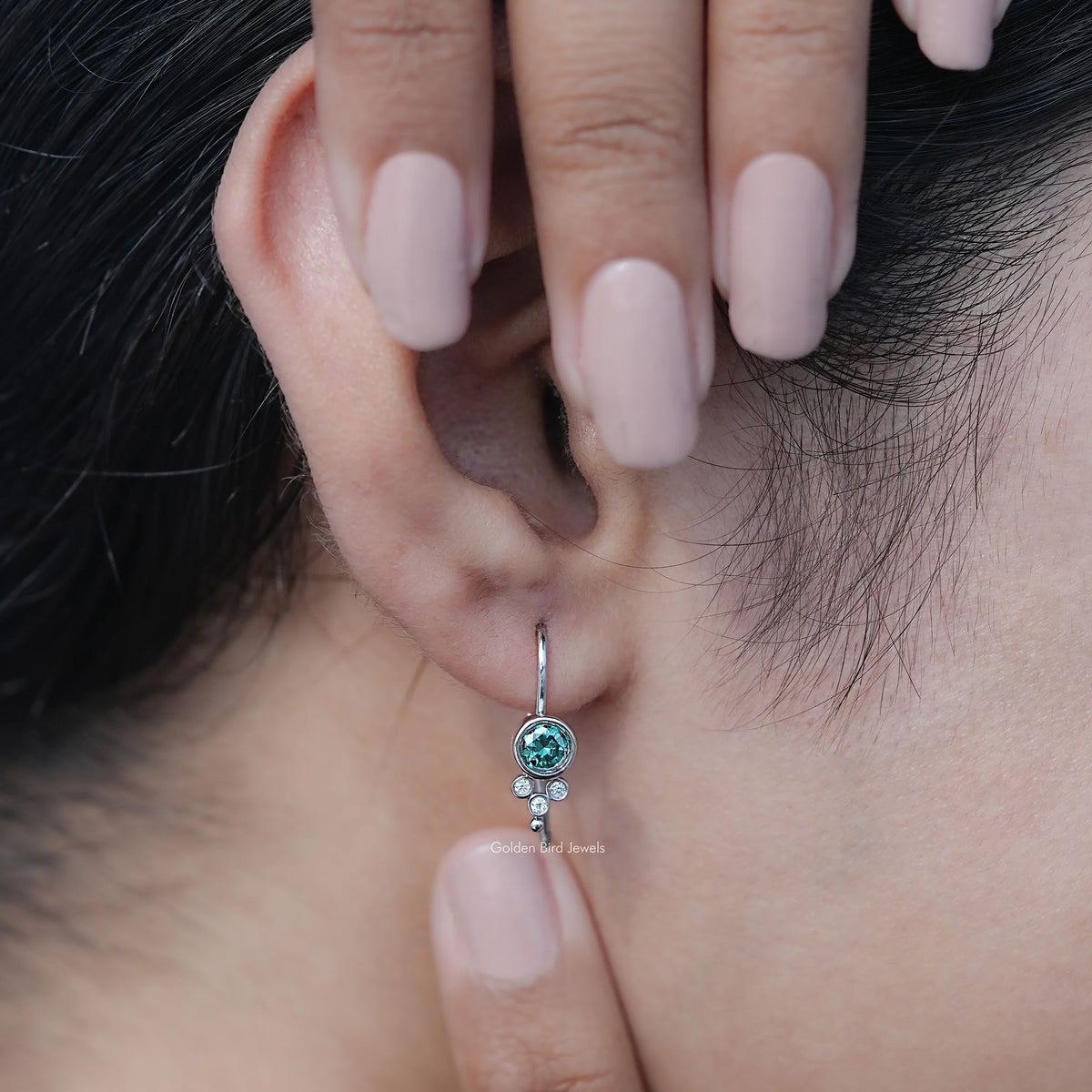 In Hand View Of Green Round Cut Moissanite Drop Earrings