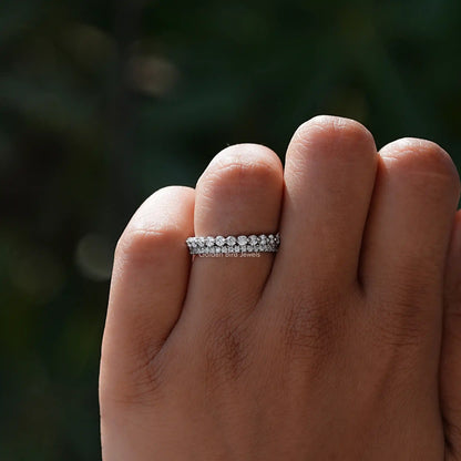 Silver two-row eternity band ring with small round stones on an open hand