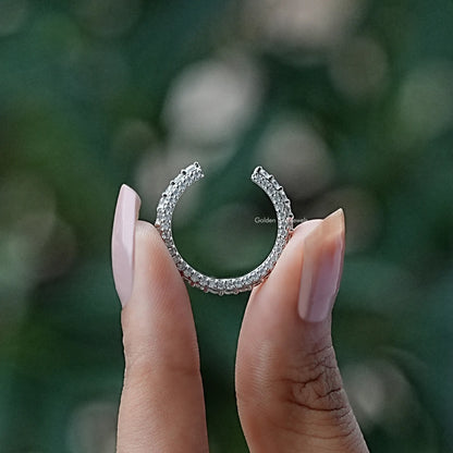 Open moissanite eternity band ring with round stones, silver-tone, side view on hand