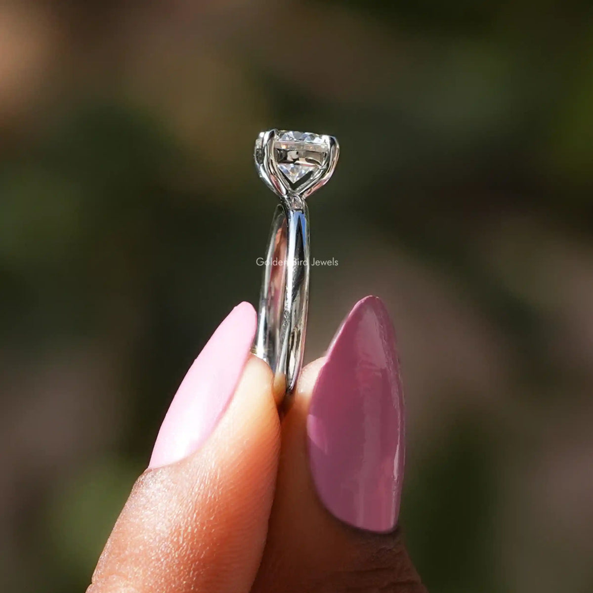 Side View of Round Cut Moissanite Engagement Ring Set In two fingers