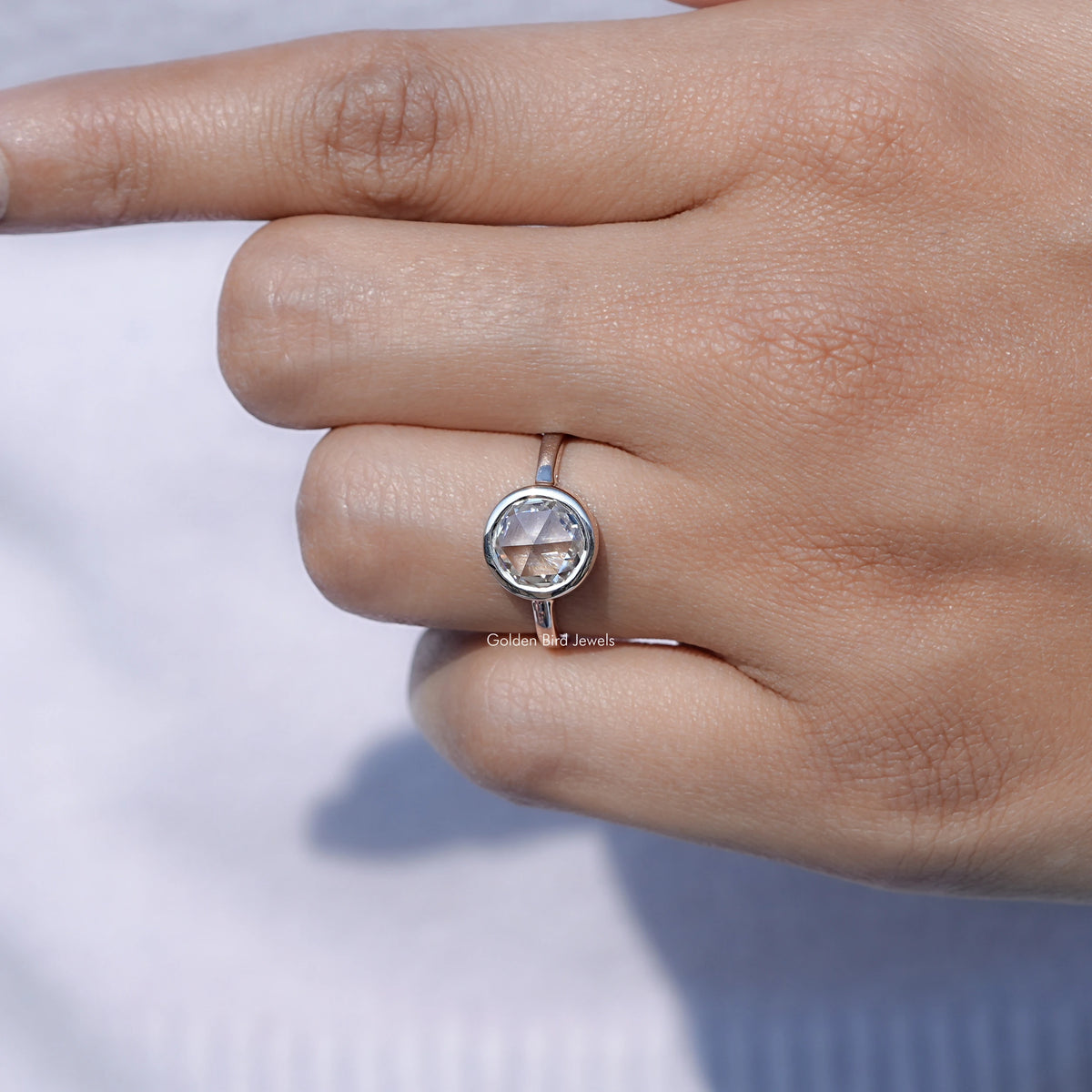 Moissanite solitaire ring with round center stone, prong-set in a silver-tone band