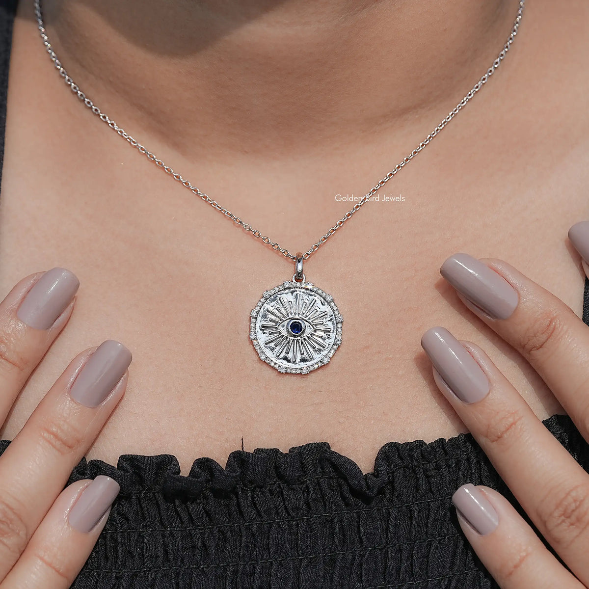 Round evil eye halo pendant with blue center gemstone and sparkling silver bezel on chain
