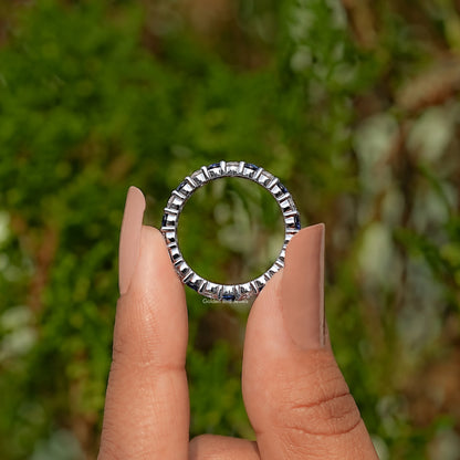 Silver-toned eternity wedding band with round blue gemstones in a full row