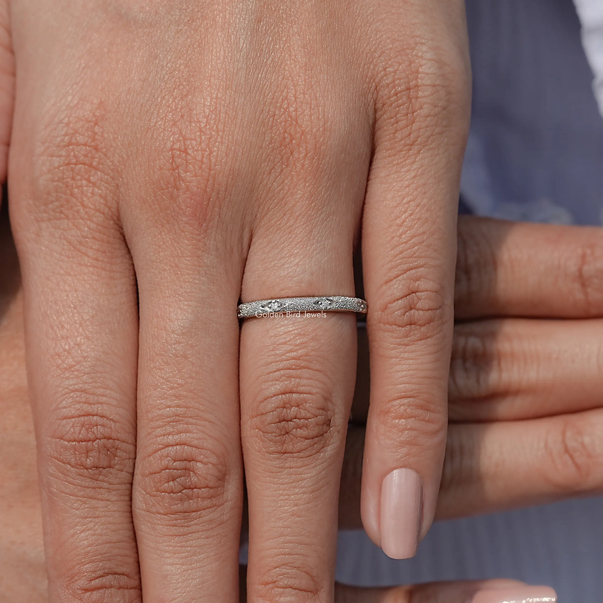 Moissanite eternity wedding band with pavé-set round stones on a finger